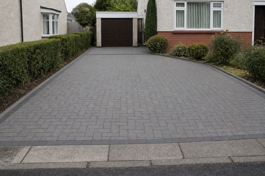The same driveway resurfaced in block paving with a concrete kerb edge.